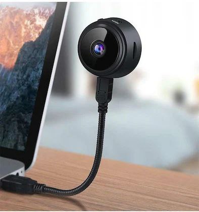 A compact wireless WiFi security camera with a black and white exterior, showing the camera itself, the magnetic mount, and a smartphone displaying the camera's view.